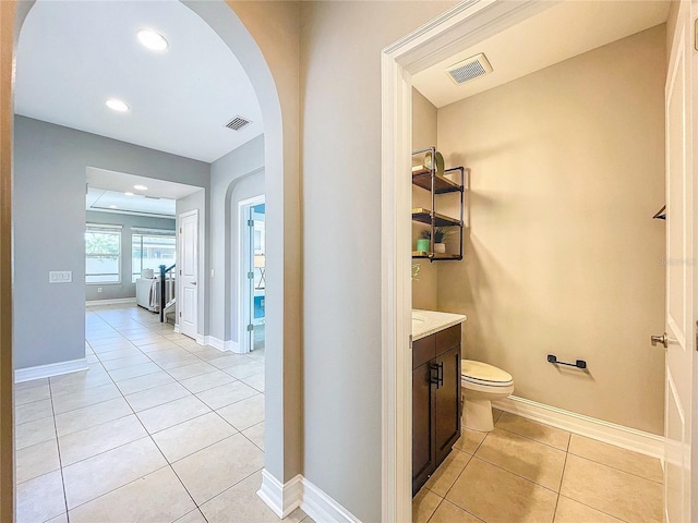 bathroom featuring vanity, tile patterned floors, and toilet