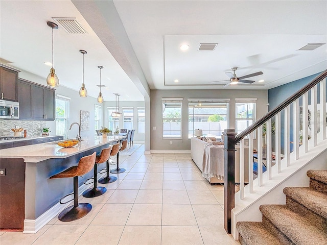 tiled living room featuring sink, a wealth of natural light, and ceiling fan