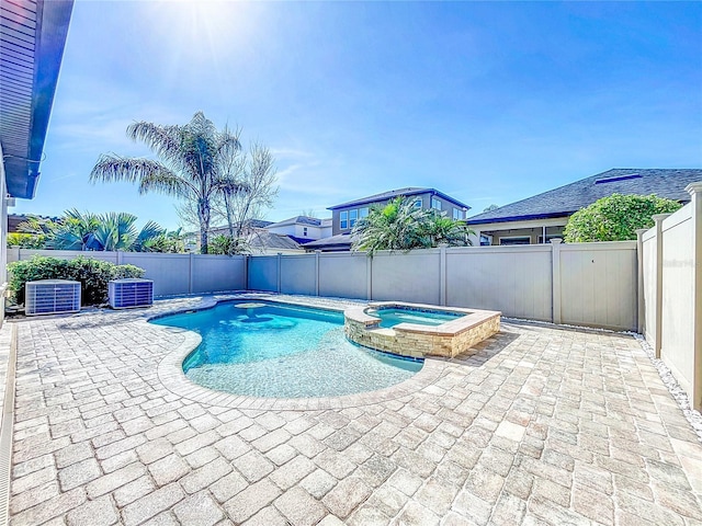 view of pool with an in ground hot tub, central AC unit, and a patio area