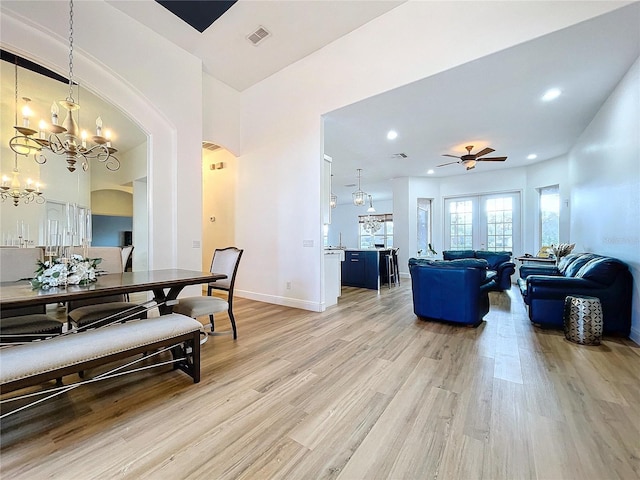 dining room featuring ceiling fan with notable chandelier and light wood-type flooring