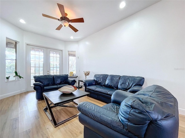 living room featuring ceiling fan, light hardwood / wood-style floors, and french doors