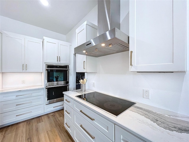 kitchen featuring white cabinetry, black electric stovetop, ventilation hood, and double oven