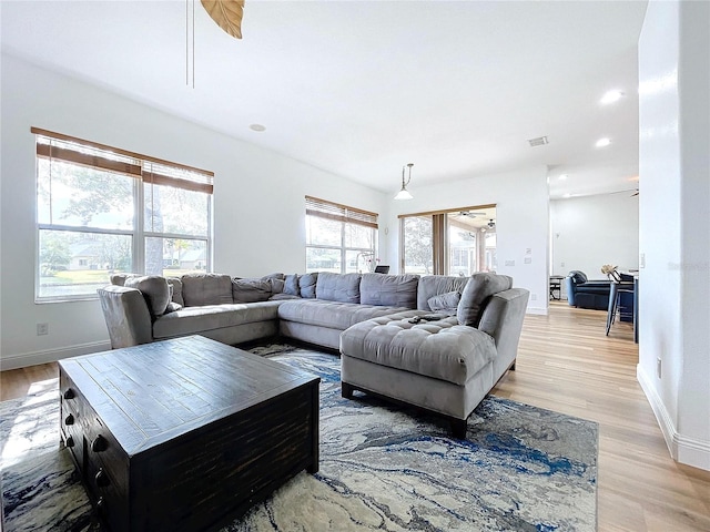 living room featuring ceiling fan and light hardwood / wood-style floors