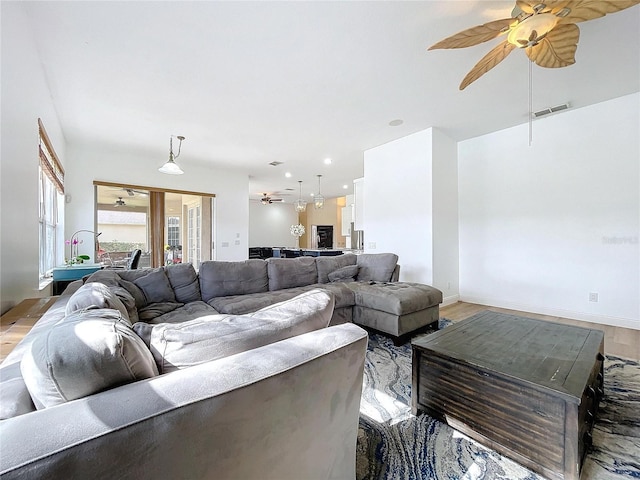 living room with ceiling fan and light hardwood / wood-style flooring