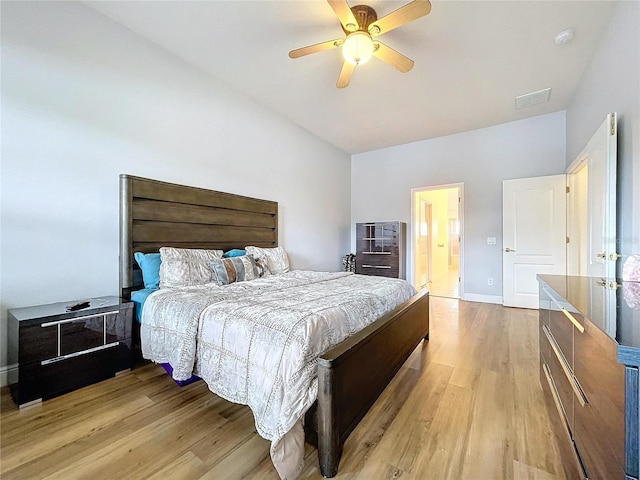 bedroom featuring ceiling fan, connected bathroom, and light wood-type flooring