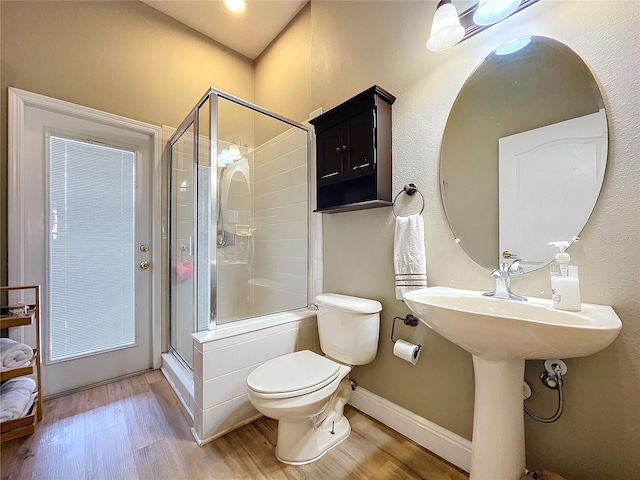 bathroom featuring walk in shower, toilet, and hardwood / wood-style flooring