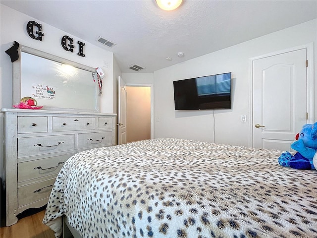 bedroom featuring hardwood / wood-style floors and a textured ceiling