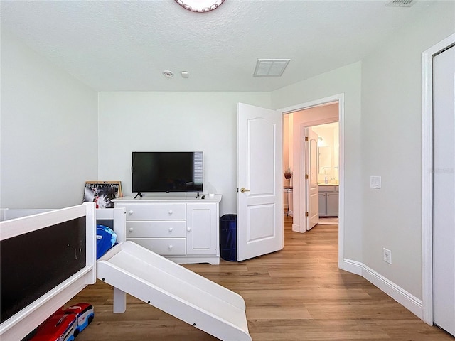 bedroom featuring light hardwood / wood-style flooring and a textured ceiling