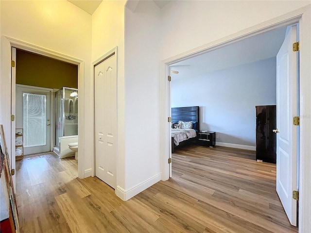 hallway with light wood-style flooring and baseboards