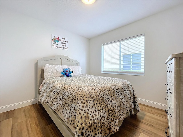 bedroom with wood finished floors and baseboards