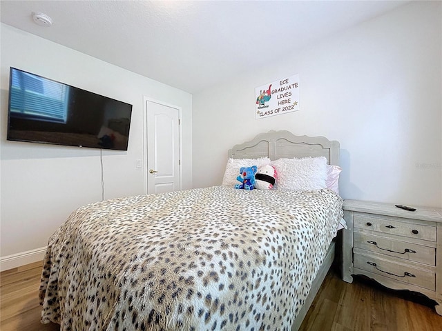 bedroom with baseboards and wood finished floors