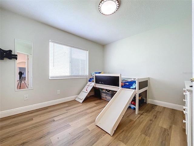 bedroom featuring light wood-style floors and baseboards