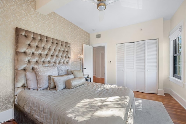 bedroom featuring hardwood / wood-style floors, ceiling fan, and a closet