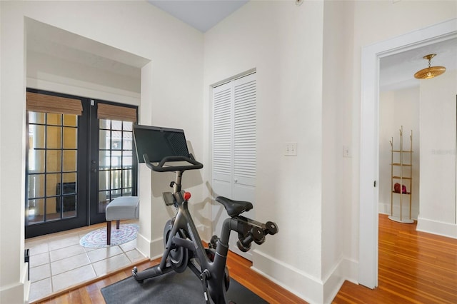 workout room with hardwood / wood-style floors and french doors