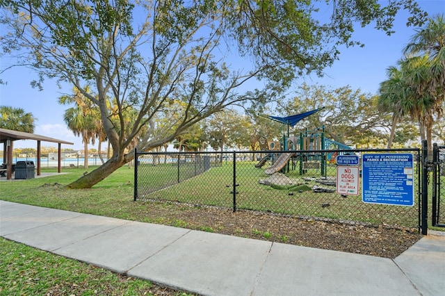 view of community with a water view, a playground, and a lawn