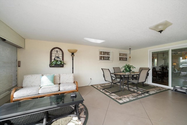 tiled living room featuring a textured ceiling