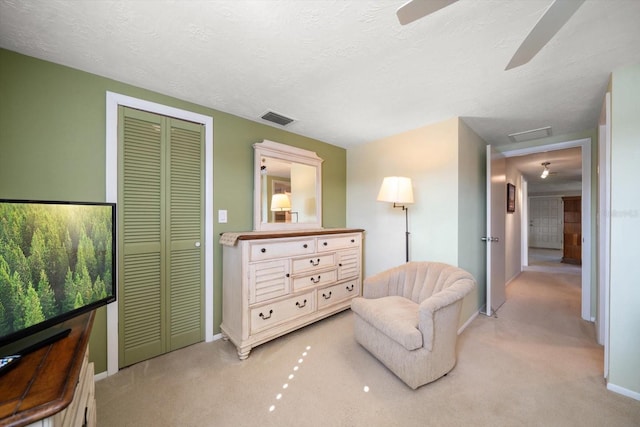 sitting room with light carpet and a textured ceiling