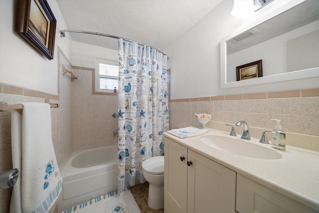 full bathroom with vanity, toilet, tile walls, and shower / bath combo with shower curtain