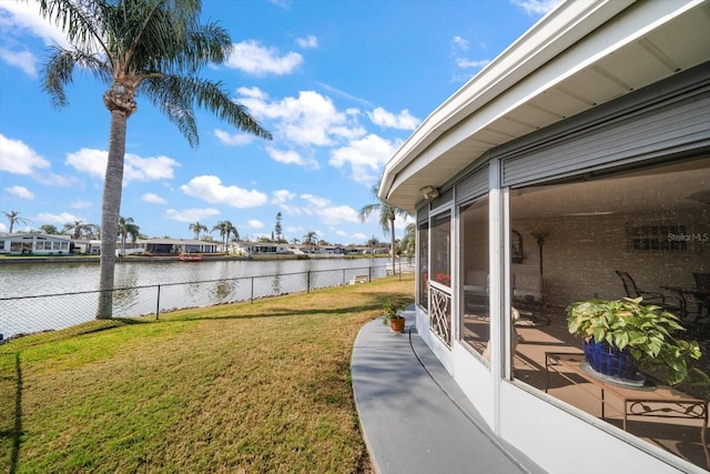 view of yard featuring a water view and a sunroom