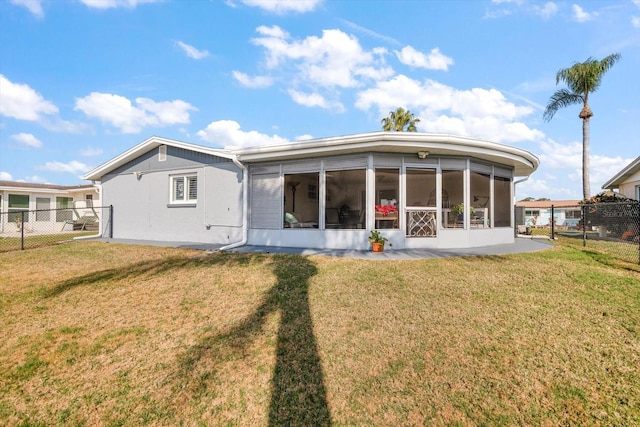 back of property with a yard and a sunroom