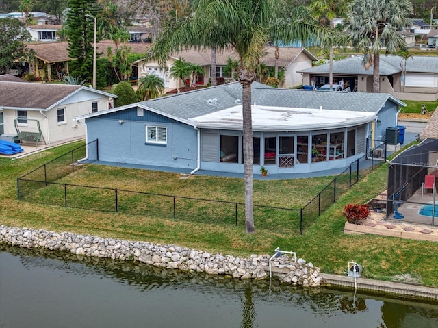 back of house featuring a water view, a lawn, central air condition unit, and a lanai