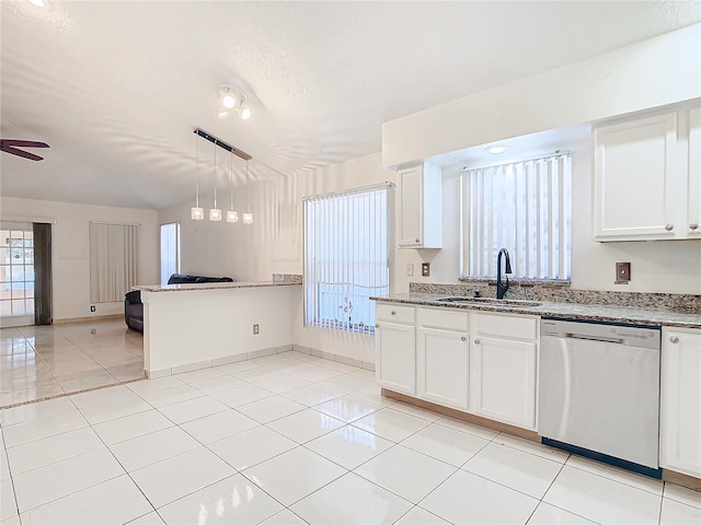 kitchen with sink, light tile patterned floors, stainless steel dishwasher, pendant lighting, and white cabinets