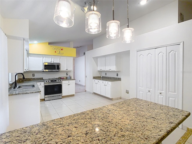 kitchen with sink, white cabinetry, hanging light fixtures, light tile patterned floors, and appliances with stainless steel finishes