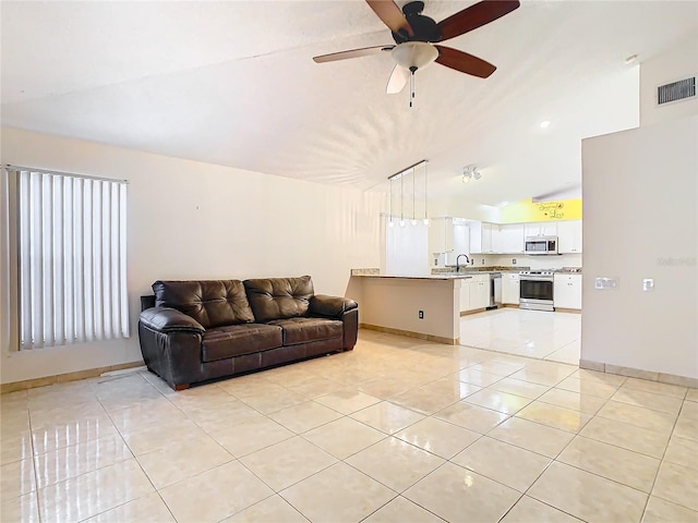 tiled living room featuring ceiling fan, lofted ceiling, and sink