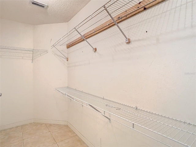 spacious closet with light tile patterned floors