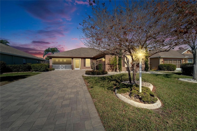 view of front of home featuring a garage and a yard