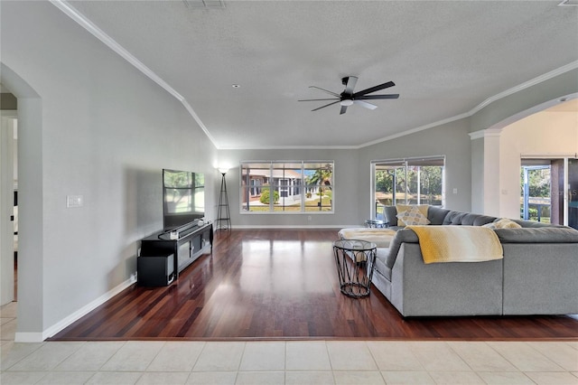 living room with crown molding, lofted ceiling, and a wealth of natural light