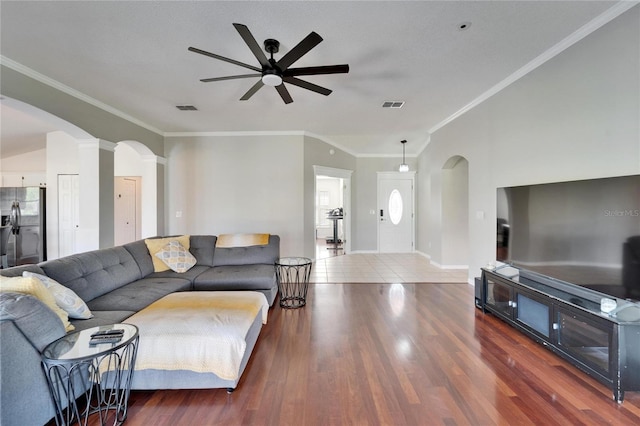 living room featuring dark wood-type flooring, ornamental molding, and ceiling fan