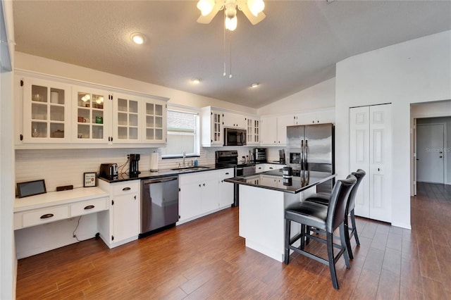 kitchen featuring white cabinetry, appliances with stainless steel finishes, a center island, and a breakfast bar area