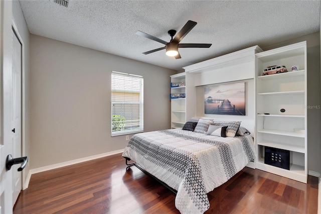 bedroom with ceiling fan, dark wood-type flooring, a closet, and a textured ceiling