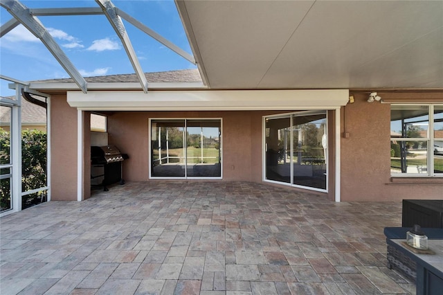 view of patio / terrace featuring a lanai, grilling area, and an outdoor kitchen