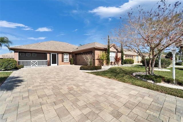 ranch-style home featuring a garage, a porch, and a front lawn