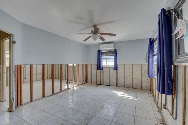 spare room featuring light tile patterned flooring, a wall mounted air conditioner, and ceiling fan