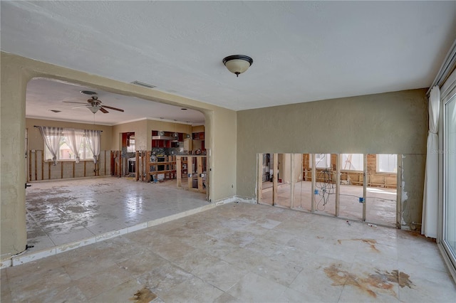 interior space with crown molding and ceiling fan