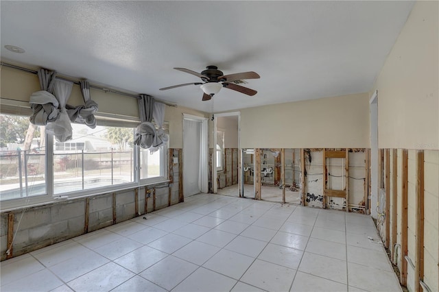 tiled spare room with ceiling fan