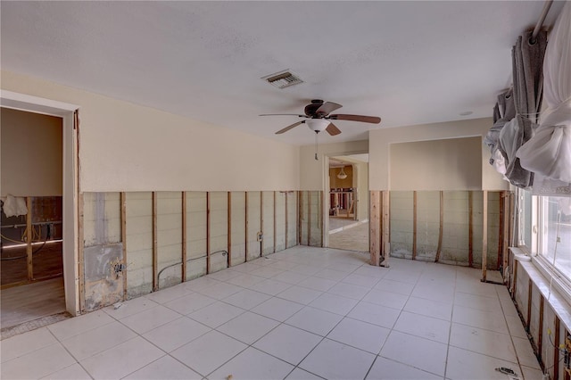 empty room with ceiling fan and light tile patterned flooring