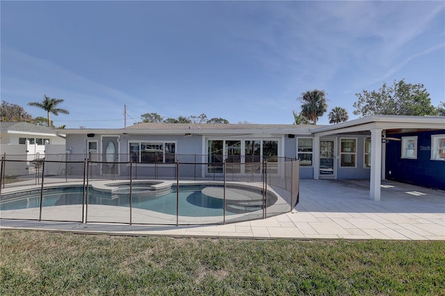 view of swimming pool with an in ground hot tub, a lawn, and a patio