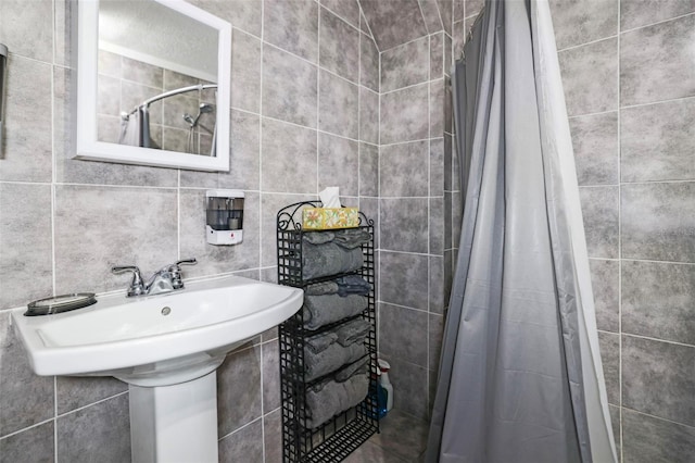 bathroom featuring a stall shower and a sink