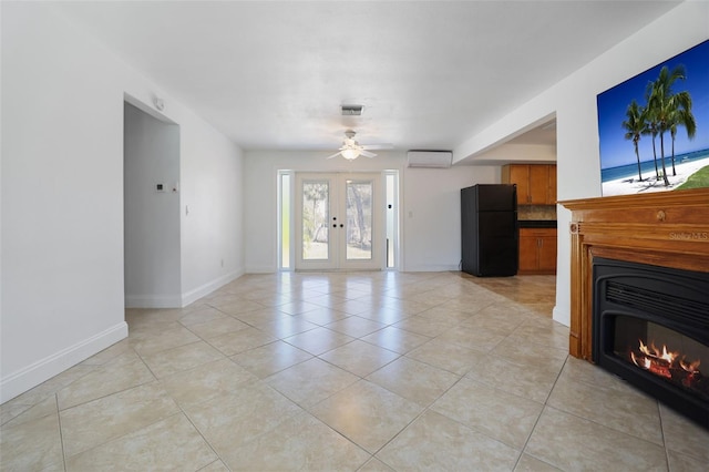 unfurnished living room with french doors, a wall unit AC, visible vents, a glass covered fireplace, and baseboards