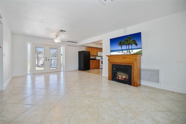 unfurnished living room with french doors, a wall unit AC, a glass covered fireplace, and visible vents