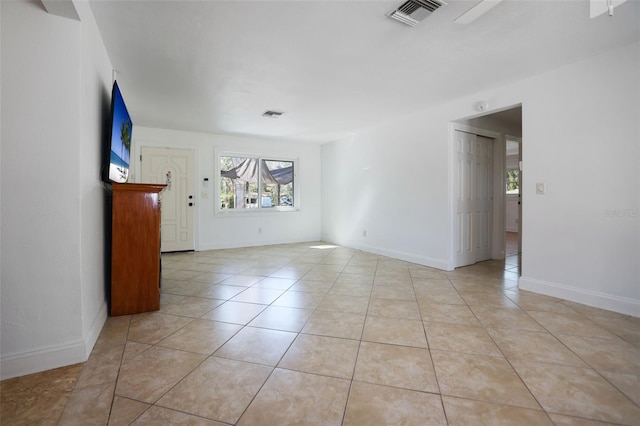 empty room with visible vents, baseboards, and light tile patterned floors