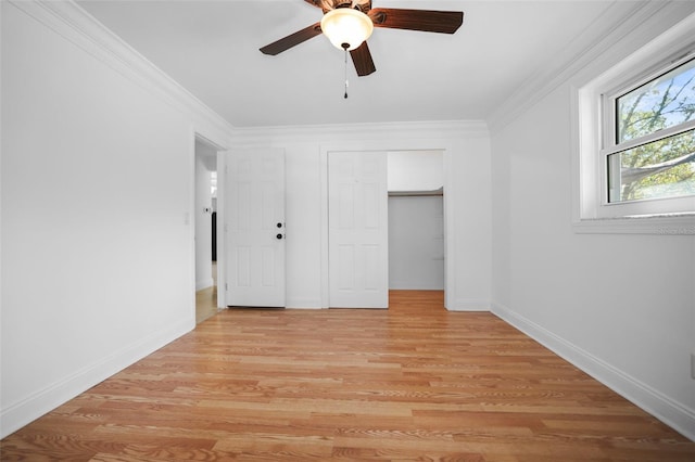 unfurnished bedroom featuring light wood-style floors, a closet, crown molding, and baseboards