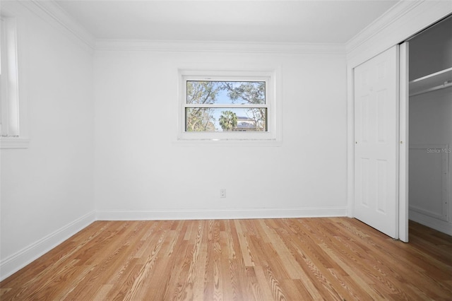 unfurnished bedroom with baseboards, a closet, light wood-type flooring, and crown molding