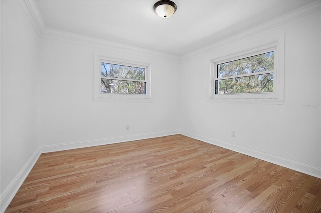 spare room with baseboards, light wood-style flooring, and crown molding