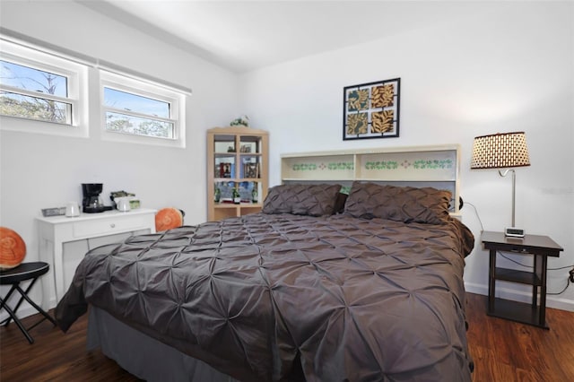 bedroom with dark wood finished floors and baseboards