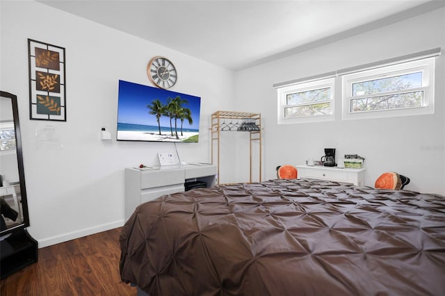 bedroom with dark wood-type flooring and baseboards